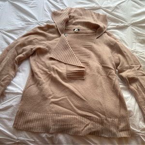 Unique pale pink sweater with zipper detail for customizable neckline
